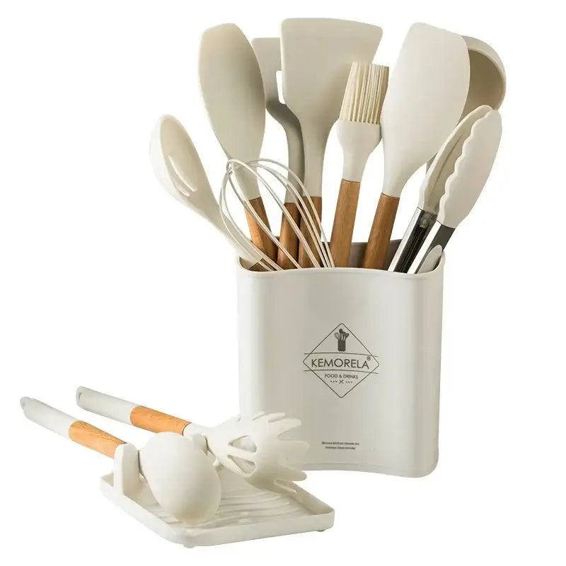 Cream-colored silicone kitchen cookware set with wooden handles neatly organized in a matching cylindrical holder container