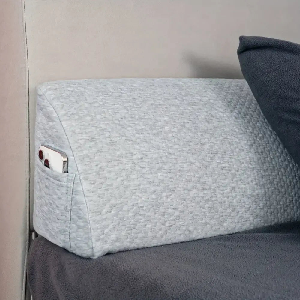Gray textured fabric pillow wedge with built-in pocket holding smartphone for decorbites headboard pillow wedge use