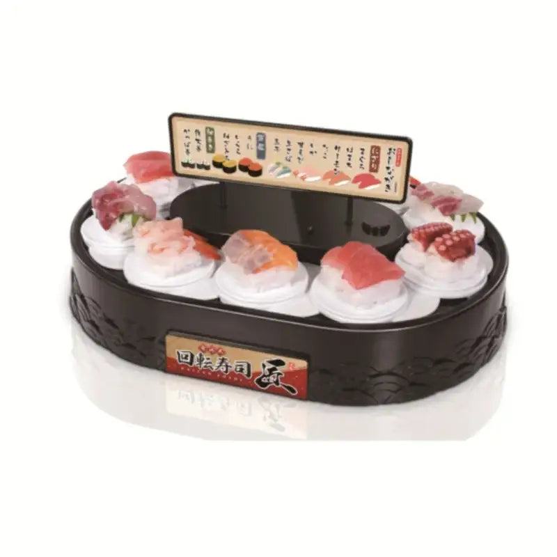 White two tiered rotating dessert table sushi machine featuring a black plastic sushi bar with colorful faux fish pieces