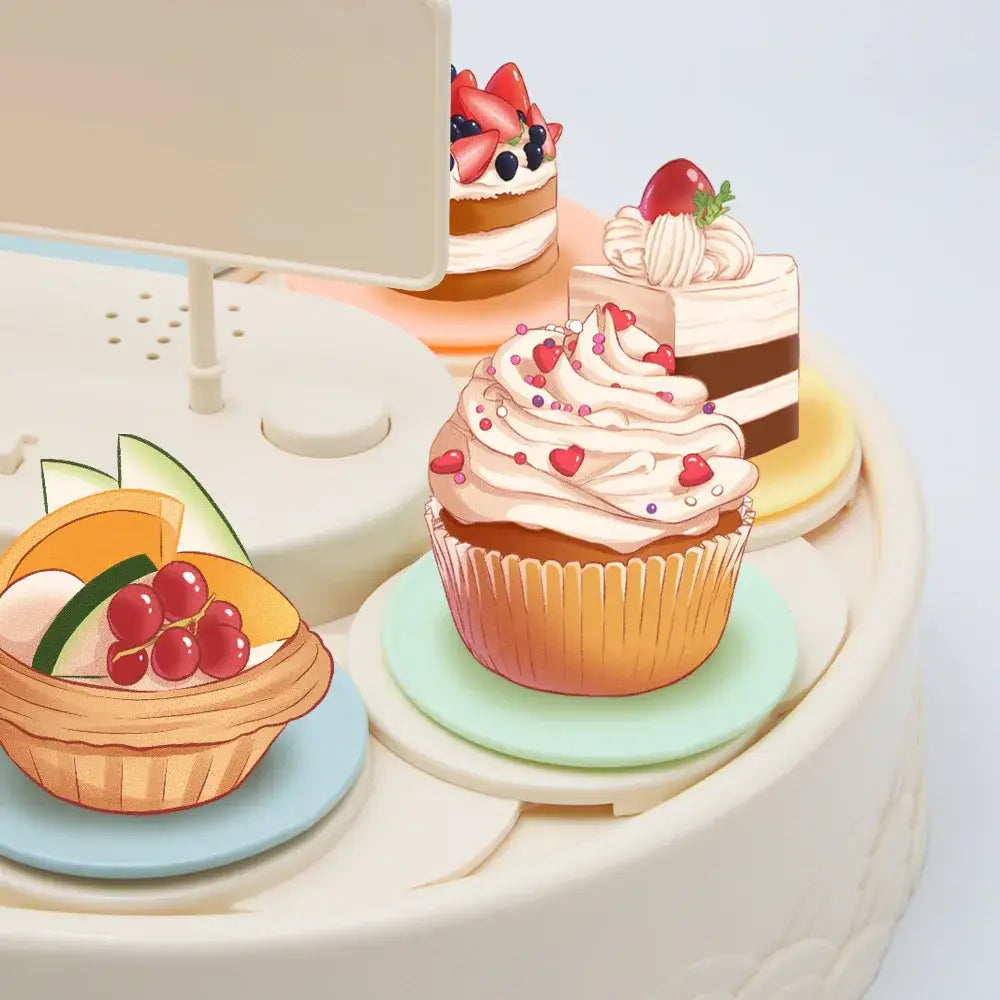 A whimsical cream-colored cupcake with pink frosting on a mint-green plate featured on a white two tiered rotating dessert table sushi machine