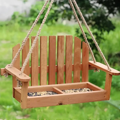Light brown wooden bird feeder chair with slatted back and divided tray filled with seeds for garden decor