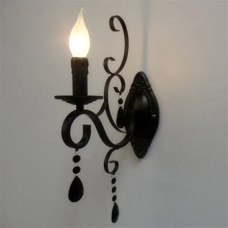 Black wrought iron wall lamp with ornate scrollwork and dangling beads for decorbites crystal deco loft use