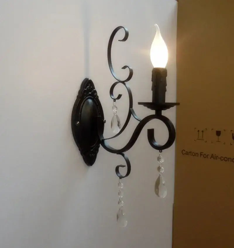 Black wrought iron wall lamp with crystal droplets and candle-style bulb for decorbites crystal deco loft use
