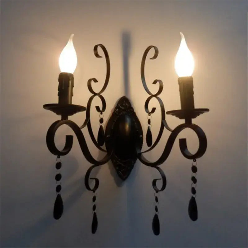 Black wrought iron wall lamp with two candle bulbs and dangling crystals decorbites crystal deco loft style