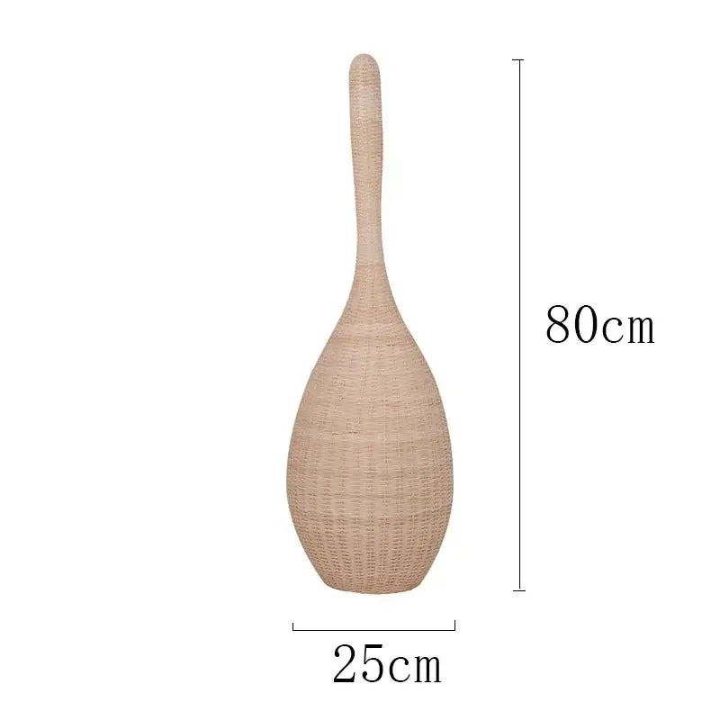 Tall beige woven rattan storage basket with slender neck and rounded base complementing bamboo floor lamp decorbites floor lamp