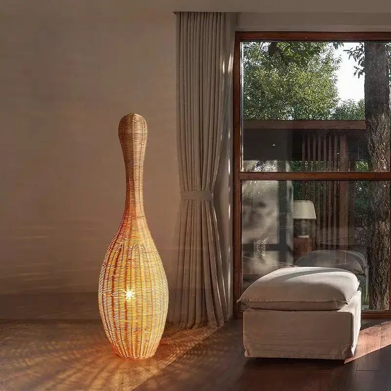 Tall slender dark brown bamboo floor lamp with woven wicker body and warm amber glow for living room decorbites decor