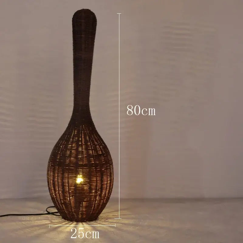 A tall dark brown woven rattan floor lamp with slender neck and bulbous base perfect as decorbites bamboo floor lamp
