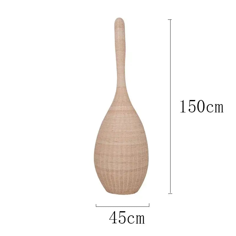 A tall beige woven rattan vase with a slender neck and rounded base complements decorbites bamboo floor lamp