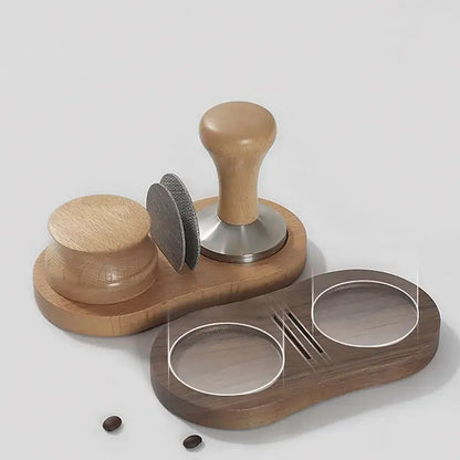 Wooden espresso distributor tamper with light brown handle and stainless steel base on dark wood tray with accessories