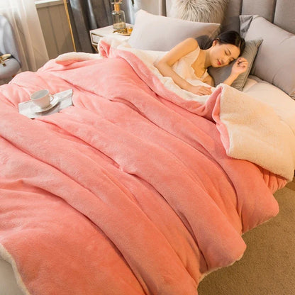 A coral-colored wool throw blanket with soft fleece texture and cream lining for winter bed and camping use
