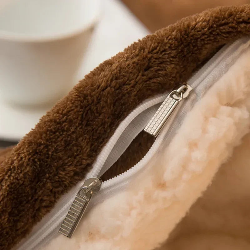 Brown plush fleece-lined zipper pouch with cream interior and silver zippers on a wool throw blanket for winter warmth