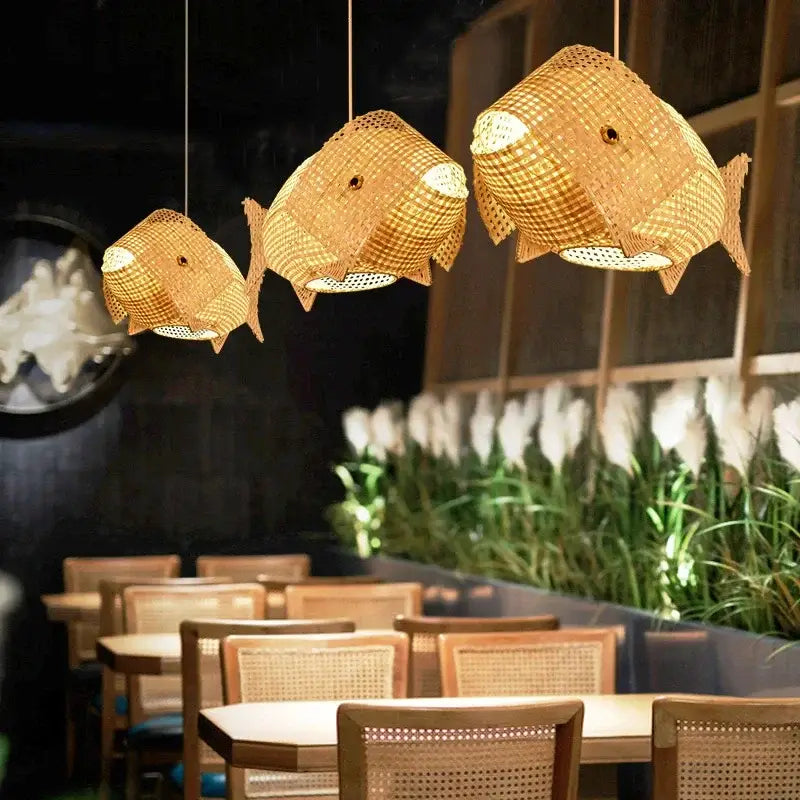 Three woven bamboo fish art pendant lights in natural color hanging from ceiling for kitchen or living room decorbites bamboo fish
