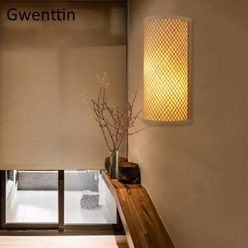 Gwenttin cylindrical bamboo wall lights sconces with woven lattice design emitting warm gold glow for bedroom