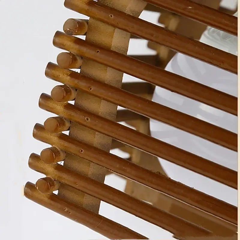 Brown bamboo chopsticks arranged in a slanted pattern complementing a warm wood tone bamboo wall sconce light for corridor