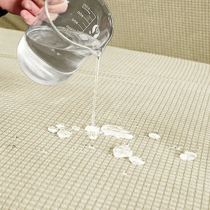 Clear glass measuring cup pouring water on beige textured mat demonstrating woven brown and cream modular sofa cover protection