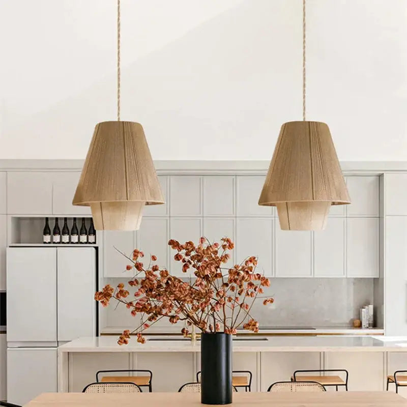 Black cylindrical vase with dried orange brown floral branches beside decorbites handmade hemp rope pendant lamp kitchen light