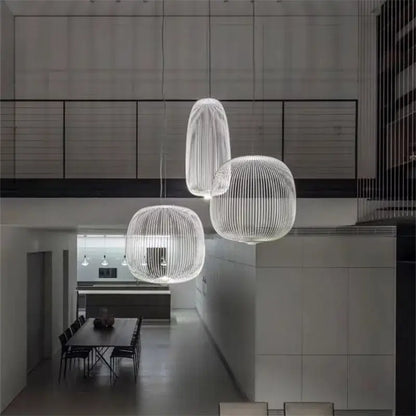 Three modern translucent white pendant lights with woven wireframe and polished chrome finish for dining room use