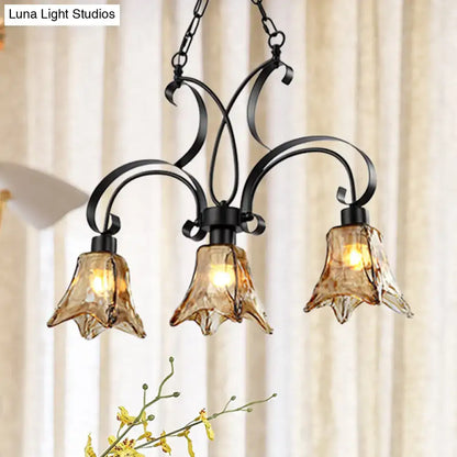 Decorbites black flower island ceiling light with black wrought iron frame and three amber textured glass shades for dining room
