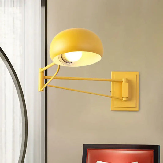 Yellow adjustable metal wall sconce with bowl shade and articulated arm for bedroom reading lighting