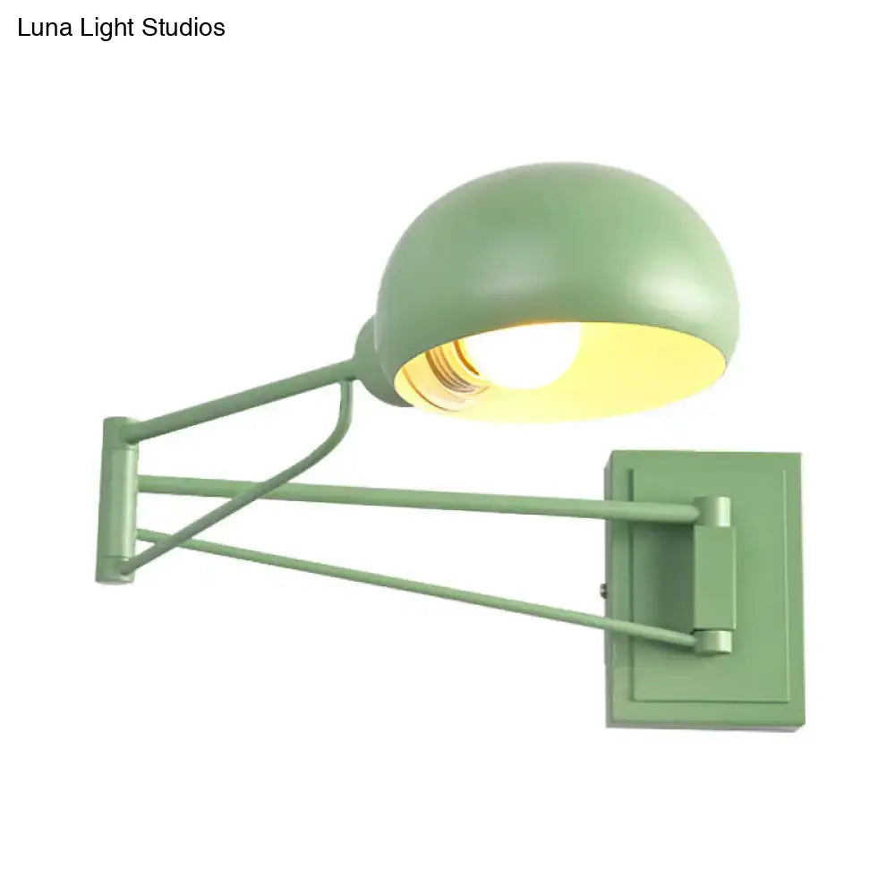 Matte sage green adjustable metal wall sconce with bowl shade and articulated arm for bedroom lighting
