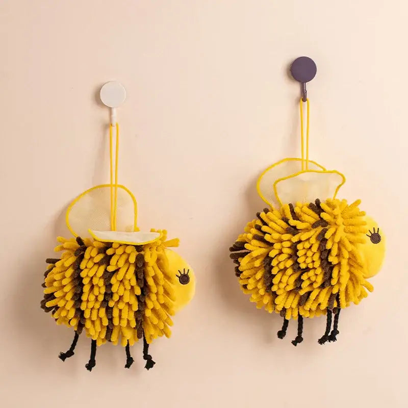 Yellow and black bee shape chenille hand towels with fuzzy texture and black legs hanging on hooks for bathroom use