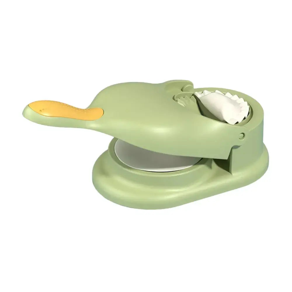 Light green plastic dumpling maker with yellow handle and white dumpling inside from yellow and blue 2-in-1 maker set