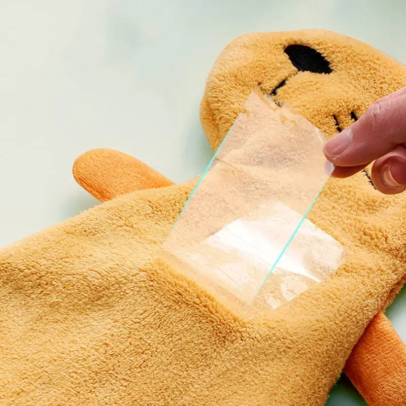 A plush tan decorbites cartoon animal hand towel with soft fuzzy texture and embroidered black facial features