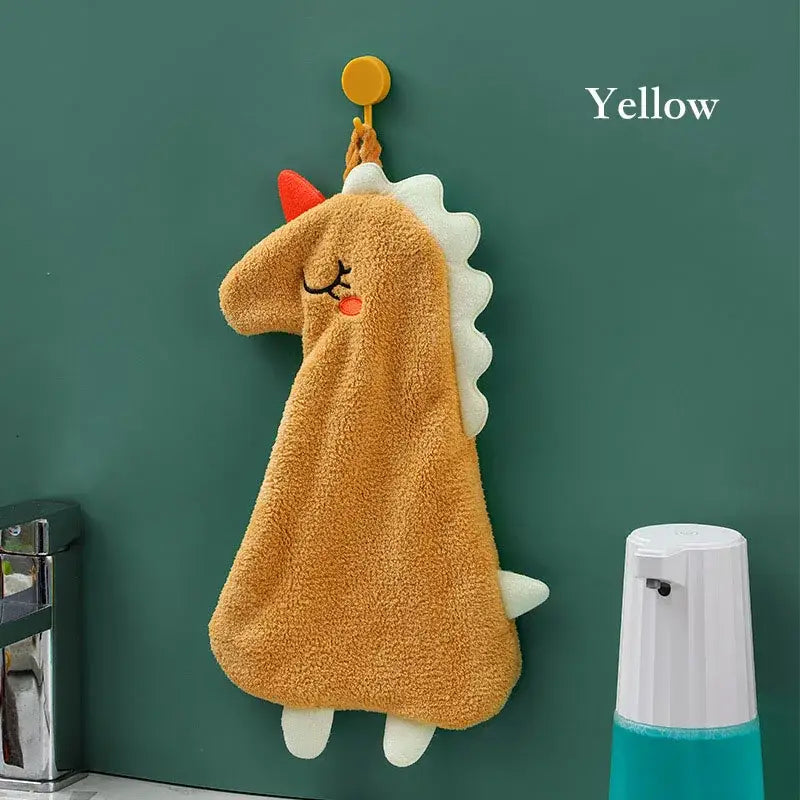 Yellow and gray decorbites cartoon animal hand towel featuring a plush tan dinosaur with white spikes and red horn hanging