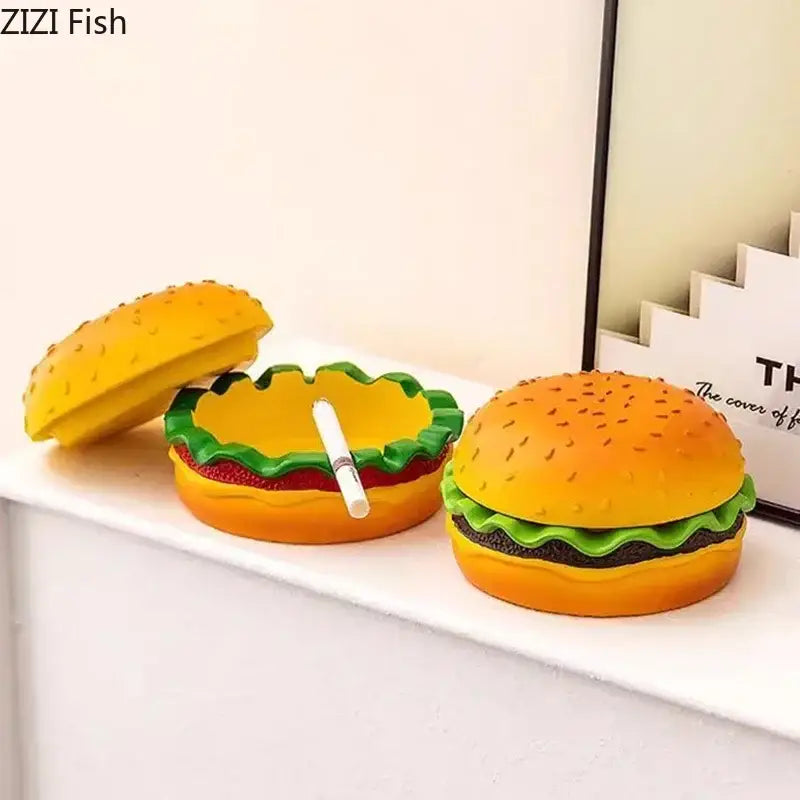Yellow and green cartoon burger ashtray made of plastic with a white cigarette inside for office table decorbites cartoon burger