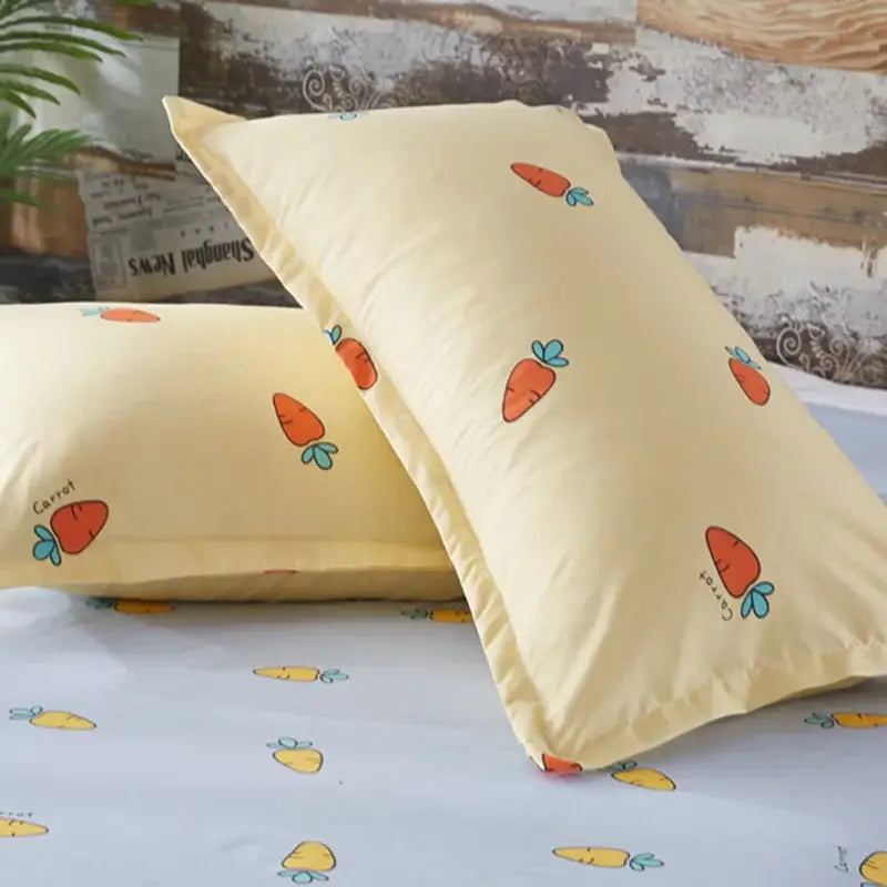 Cream-colored pillowcases with orange carrot cartoon printed pattern in yellow and light blue carrot cartoon printed bedding set