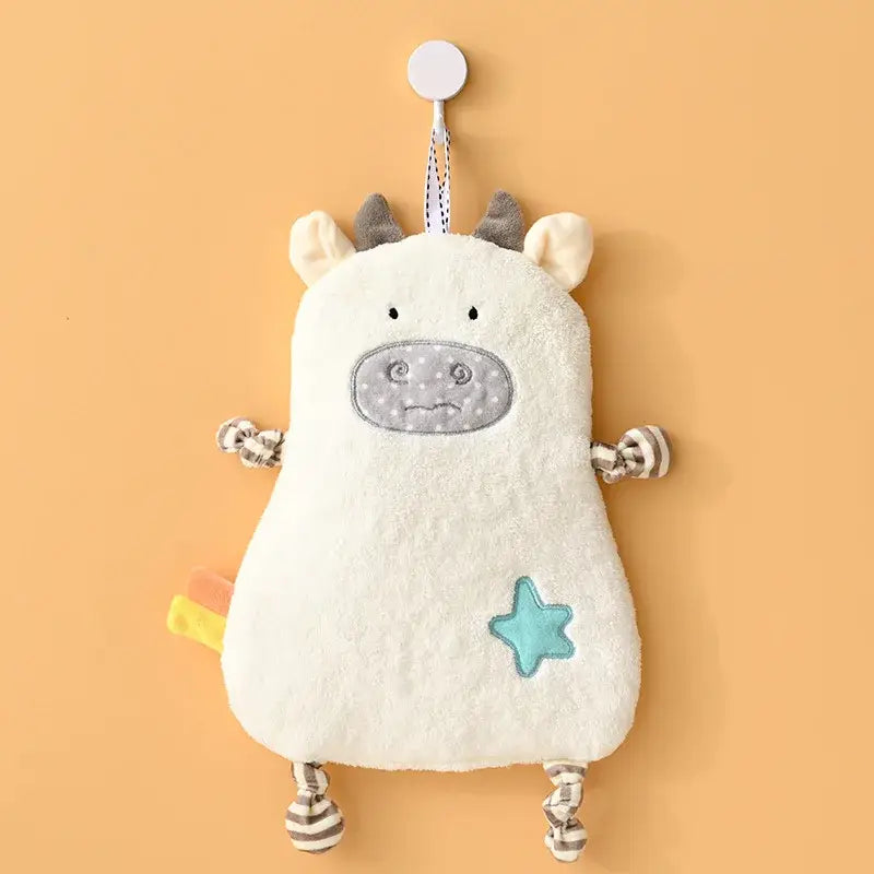 A soft white plush cow-shaped hand towel with gray ears and star patch for yellow and pink cartoon animal decorbites decor