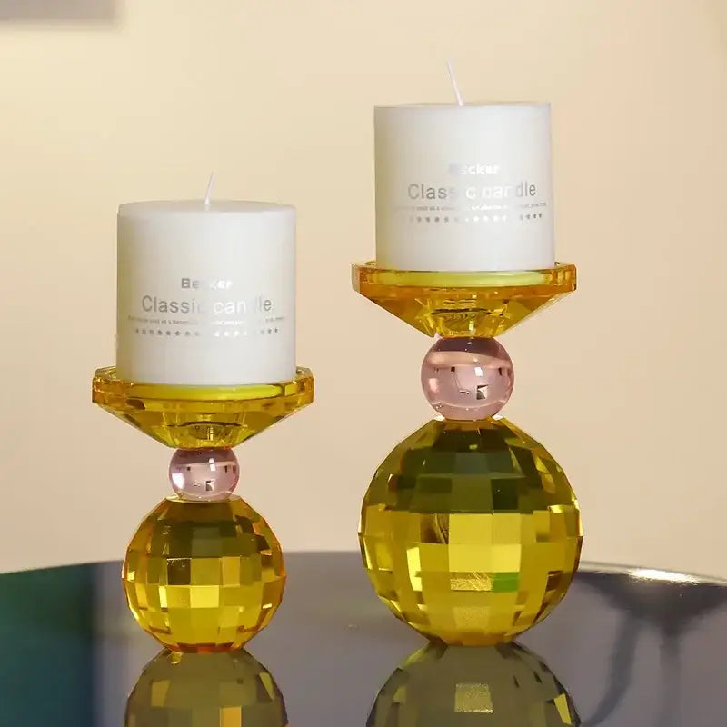 Yellow and pink crystal candle holder with white pillar candles designed as a dining room centerpiece