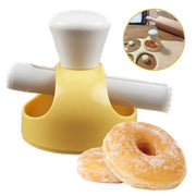 Yellow plastic donut cutter with white handle and rolling pin attachment in a baking tools kit for kitchen use