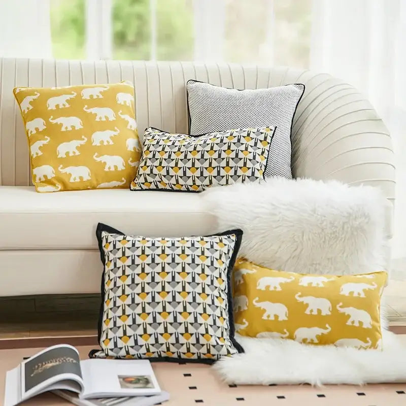 Yellow cushion cover with a white geometric elephant pattern for living room decor by decorbites geometric elephant