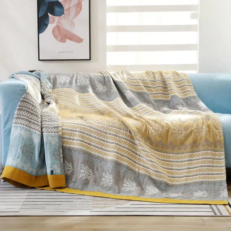 A soft cotton stripe gauze towel quilt in muted gray yellow and light blue with intricate geometric designs for summer bedroom use