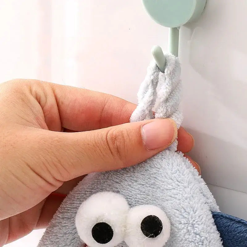 Gray plush monster-shaped hand towel with googly eyes hanging on hook for bathroom decorbites cartoon pig use