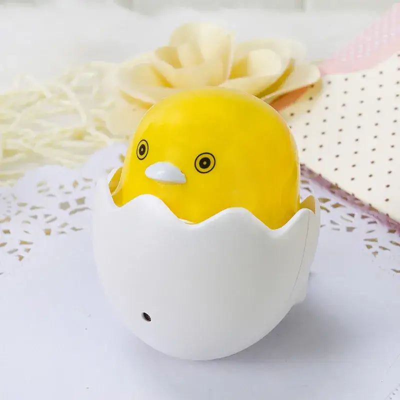 Yellow chick figurine with black eyes peeking from a glossy white eggshell led night light bedroom sensor lamp