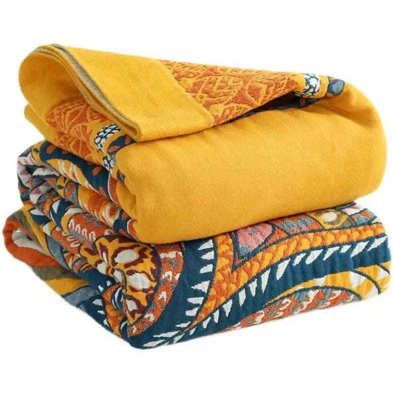 Stacked quilted decorbites cotton mandala leisure blankets in vibrant yellow and bold orange-blue paisley patterns