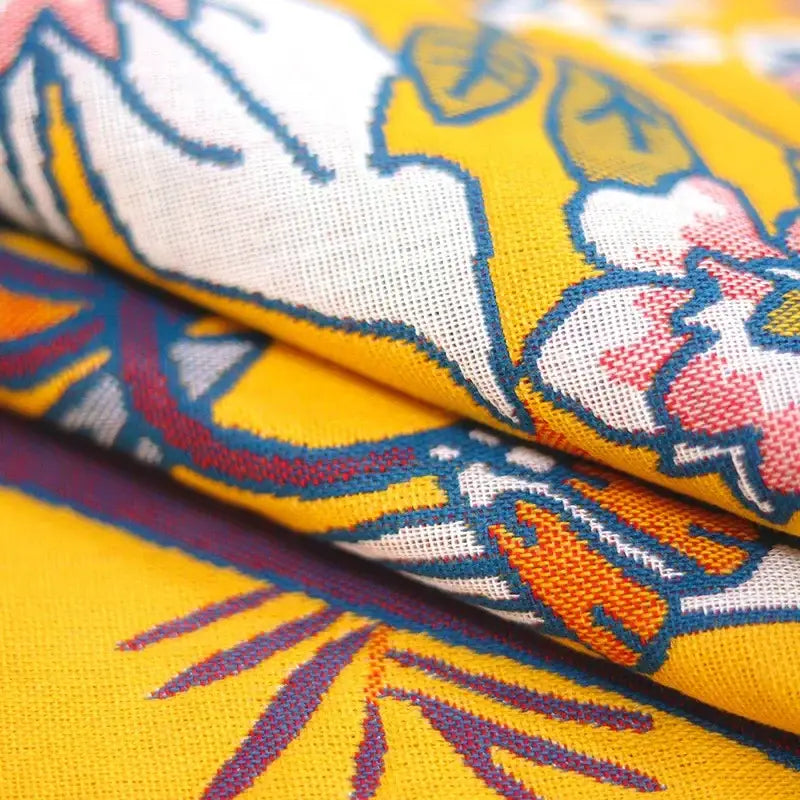 Yellow floral and bird cotton large bath towel with vibrant yellow fabric and bold white pink orange and blue floral pattern