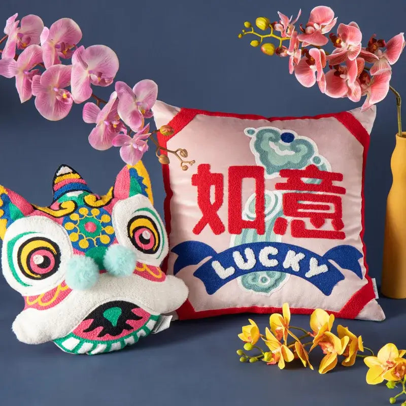 Yellow good fortune embroidered cushion cover featuring a vibrant chinese lion head plush with colorful patterns and pom-poms