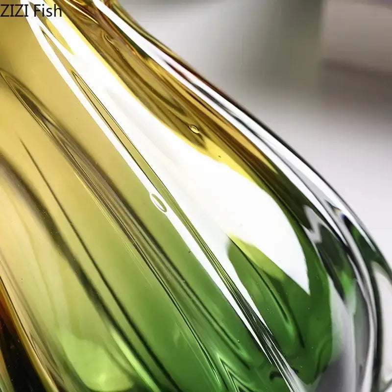 A sleek yellow and green glass vase hydroponics with gradient glass for artificial flowers in the dining room