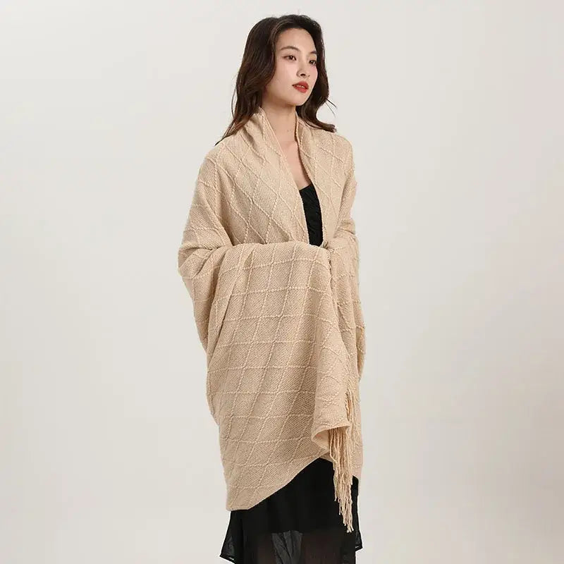 Beige decorbites knitted diamond blanket with fringe detailing used as bedroom shawl wrap