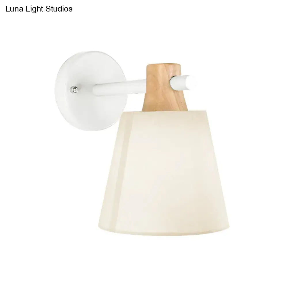 Minimalist yellow macaron fabric wall light with white circular base wood accent arm and cream tapered shade bedroom sconce