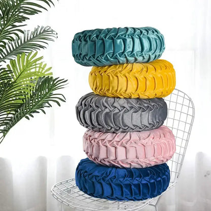 Stacked yellow pleated velvet throw pillow with teal pink gray and blue covers featuring textured decorbites 3d pumpkin design