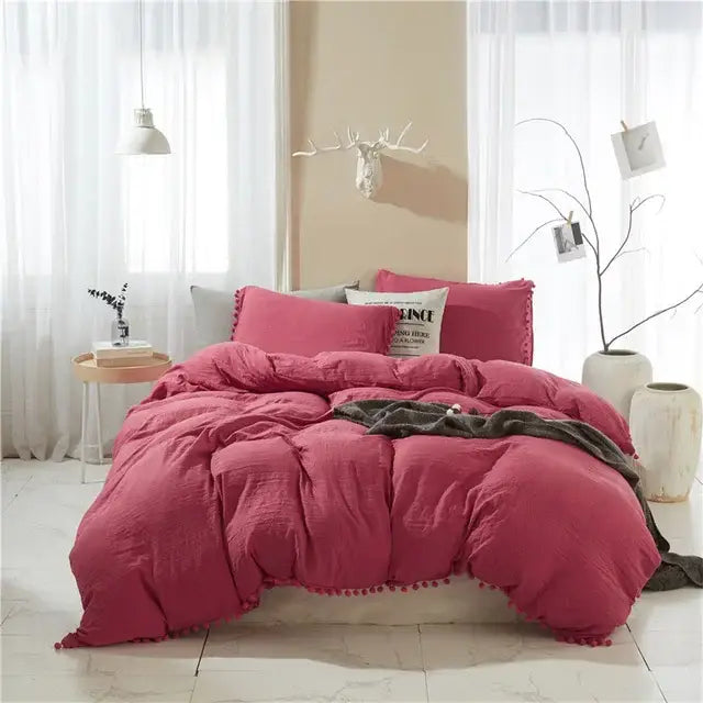 Pink textured comforter with pom-pom trim from decorbites furball tasseles bedding set for stylish bedroom decor