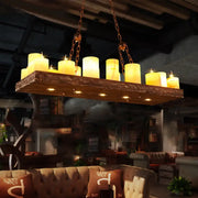 Rustic wooden chandelier with 16 yellow glowing candle-like bulbs suspended by chains wood candlestick island light fixture