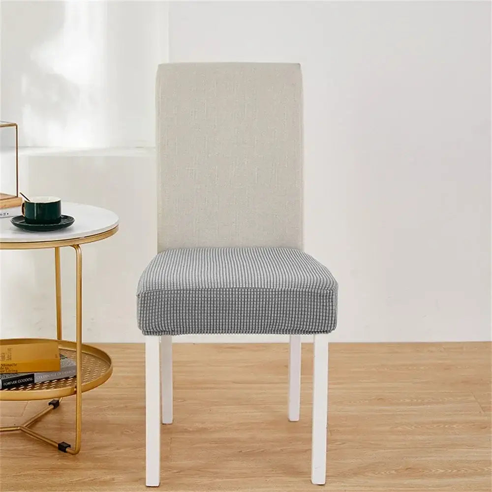 Modern dining chair with white frame and checkered seat featuring a yellow ribbed fleece chair cover for protection