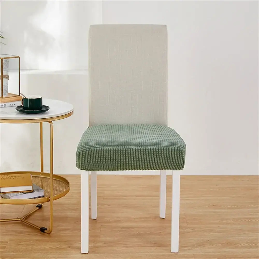 Green ribbed fleece chair cover snugly fits over white dining chair for seat protection and style with chair covers