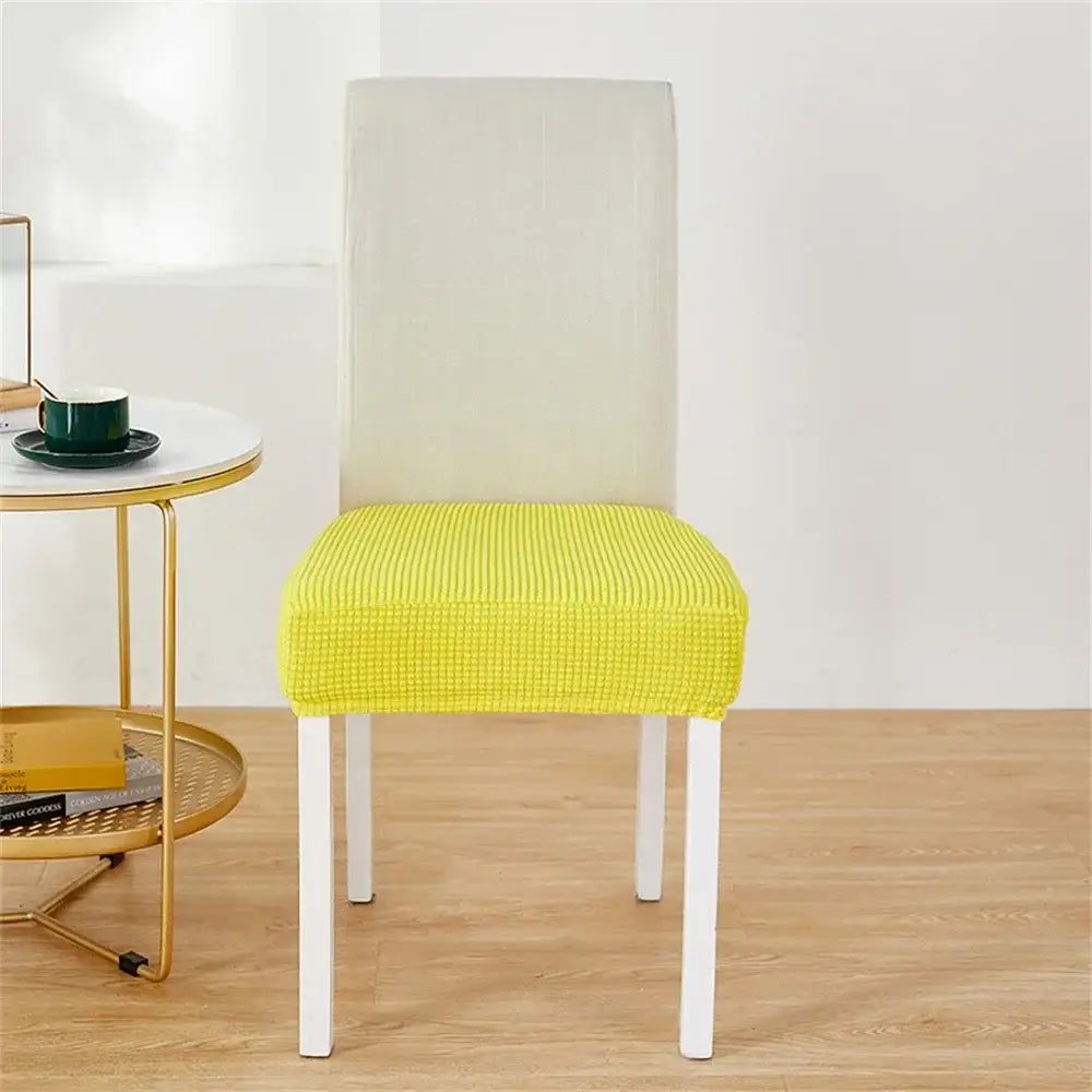 Bright yellow ribbed fleece chair cover snugly fits white dining chair for seat protection and style