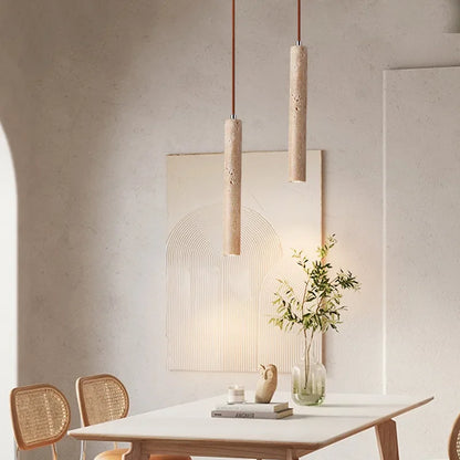 Yellow stone pendant light with two beige textured concrete stone pendant lights suspended by brown cords for bedroom